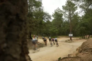 Gravel riders cycle over a dusty forest path in Girona during a Ride Up gravel route