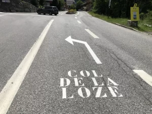 Wegmarkering richting Col de la Loze op het asfalt tijdens de klim in de Franse Alpen