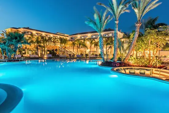 Verlicht zwembad van een luxe fietshotel in Calpe met palmbomen tijdens een Ride Up trainingsweek.