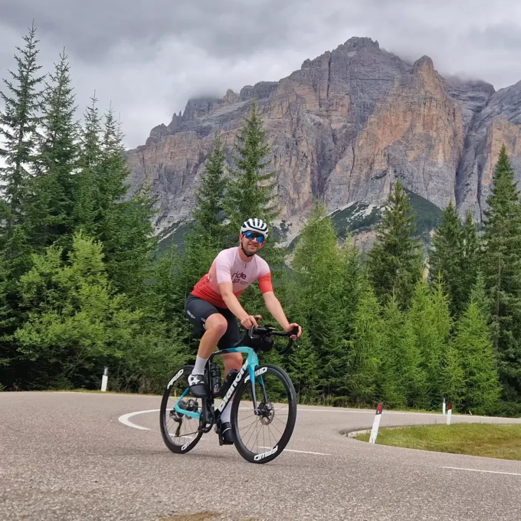 Wielrenner op een bergweg met uitzicht op de Alpen