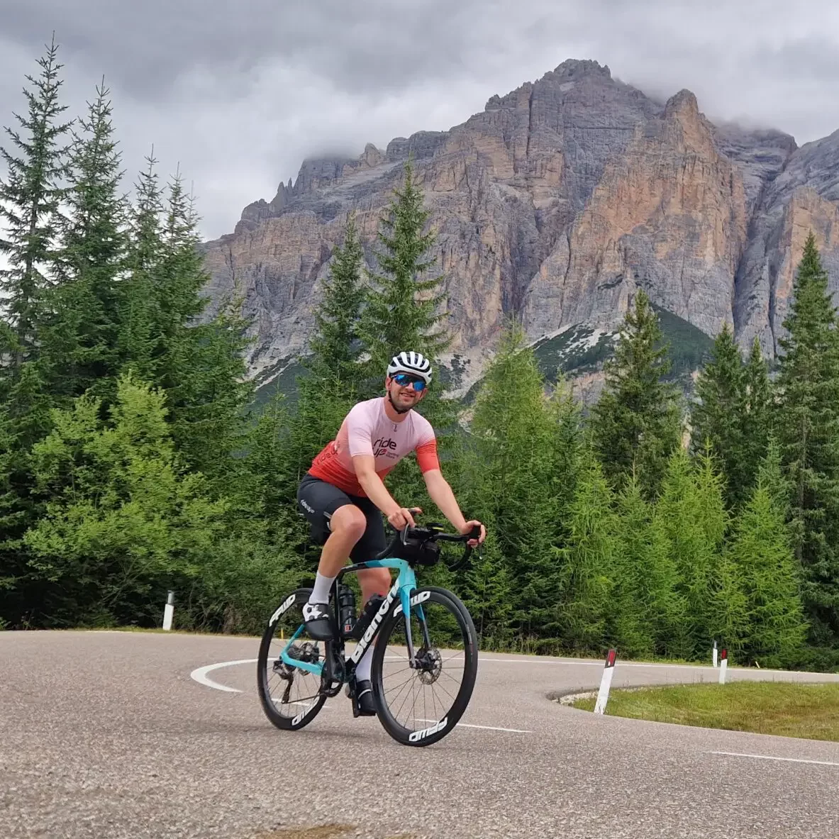Wielrenner op een bergweg met uitzicht op de Alpen