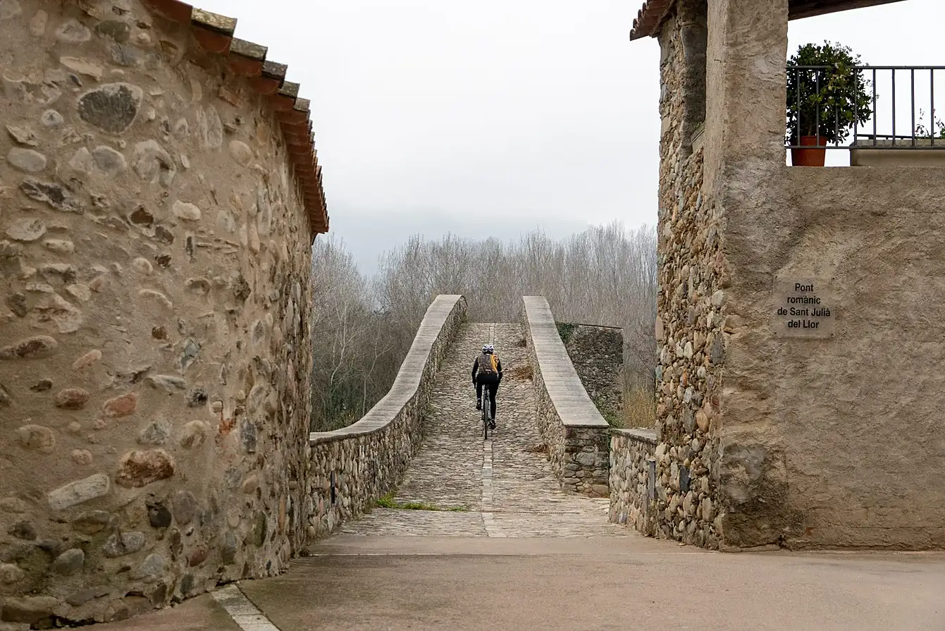 Gravelpad tussen oude stenen muren tijdens een fietsroute bij Girona